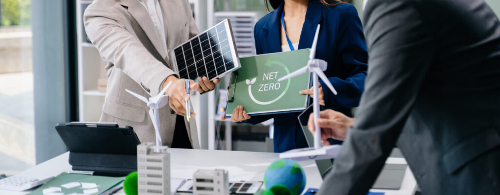 a group of people holding solar panels and wind turbines