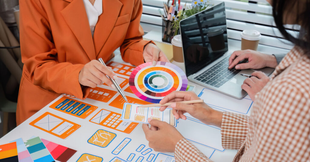website project management team sitting at a table with a laptop and a paper plate creating
